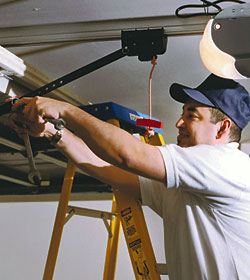 Man fixing a broken garage door spring