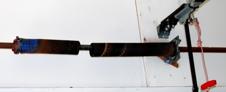 Two halves of a snapped garage door spring
