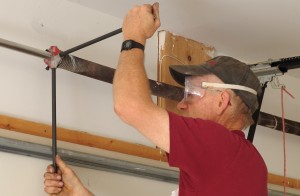 Man tightening a newly replaced garage door spring